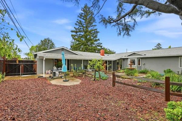 a view of a house with backyard sitting area and garden