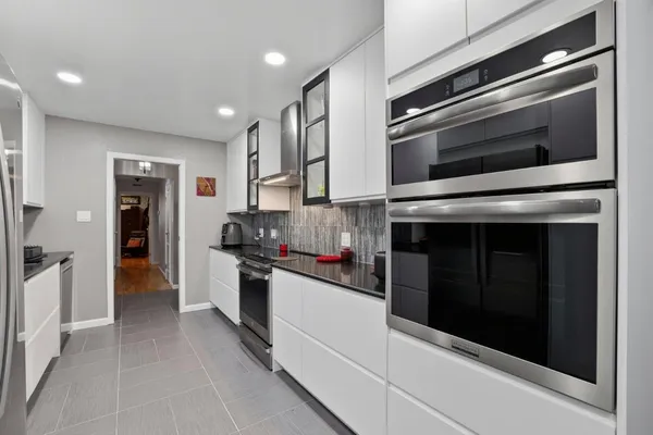 a kitchen with stainless steel appliances and stove top oven