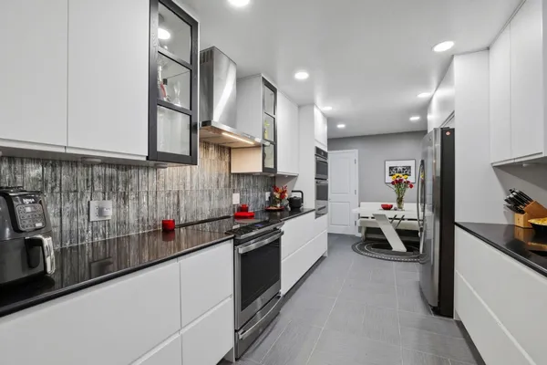 a kitchen that has a lot of cabinets and wooden floor