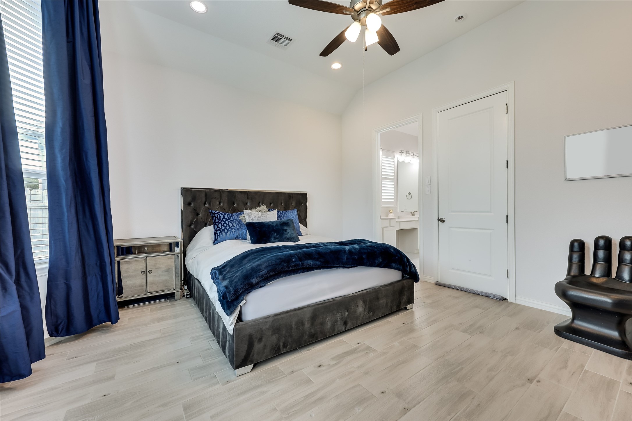 7705 Pace Ravine Drive Lago Vista, TX 78645 - Photo 15 of 40 Primary bedroom featuring light wood-style flooring, recessed lighting, ceiling fan, vaulted ceiling, and ensuite bath