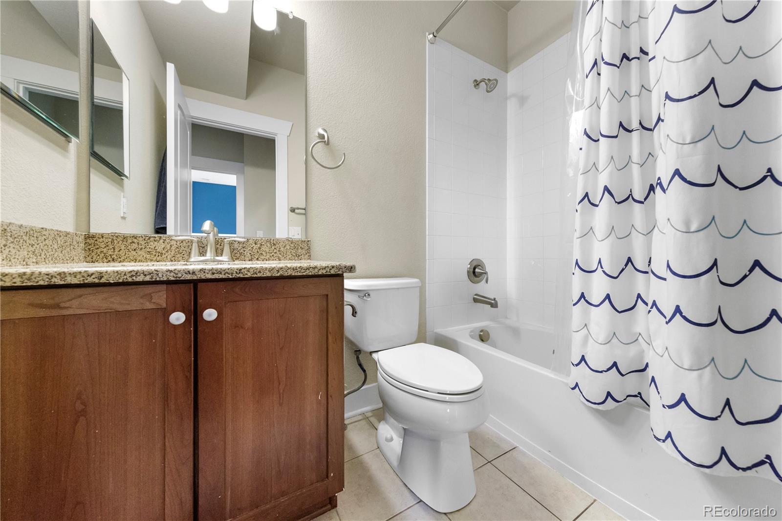 2907 Ironton Street Denver, CO 80238 - Photo 18 of 29 a spacious bathroom with a granite countertop sink a toilet and a mirror