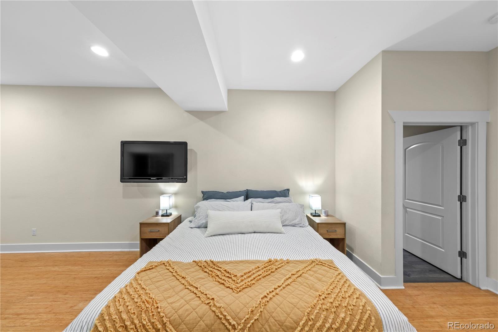 2907 Ironton Street Denver, CO 80238 - Photo 27 of 29 a bedroom with a bed and a flat screen tv