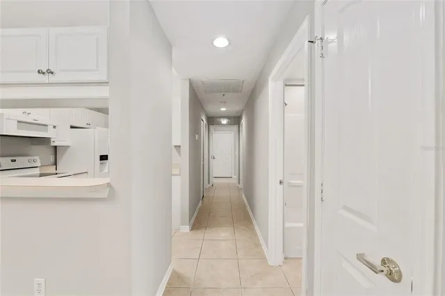 a view of a hallway with two white cabinets
