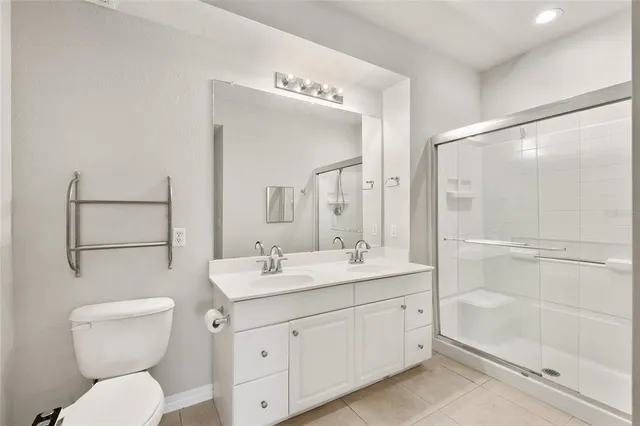 a bathroom with a toilet a sink a mirror a shower a vanity and window