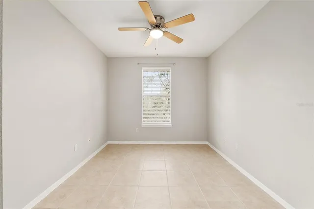 an empty room with a window and a fan