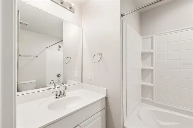 a bathroom with a sink vanity tub and shower