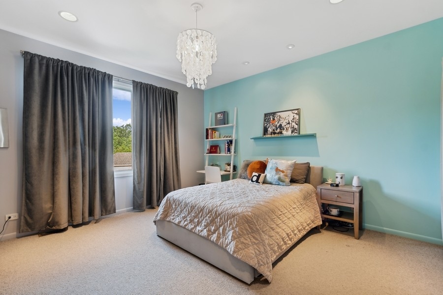 69 Riverside Drive Deerfield, IL 60015 - Photo 15 of 27 a bedroom with a bed and a chandelier