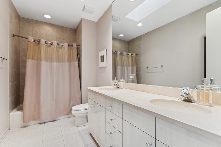 69 Riverside Drive Deerfield, IL 60015 - Photo 18 of 27 a bathroom with a double vanity sink toilet mirror and shower