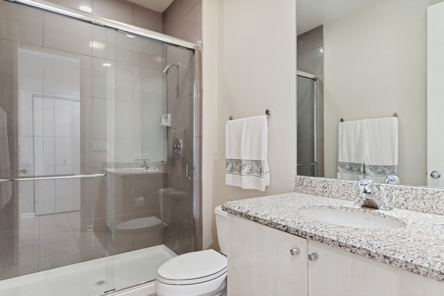 69 Riverside Drive Deerfield, IL 60015 - Photo 9 of 27 a bathroom with a granite countertop sink toilet and shower