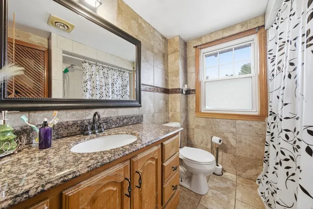 a bathroom with a granite countertop sink toilet and a shower
