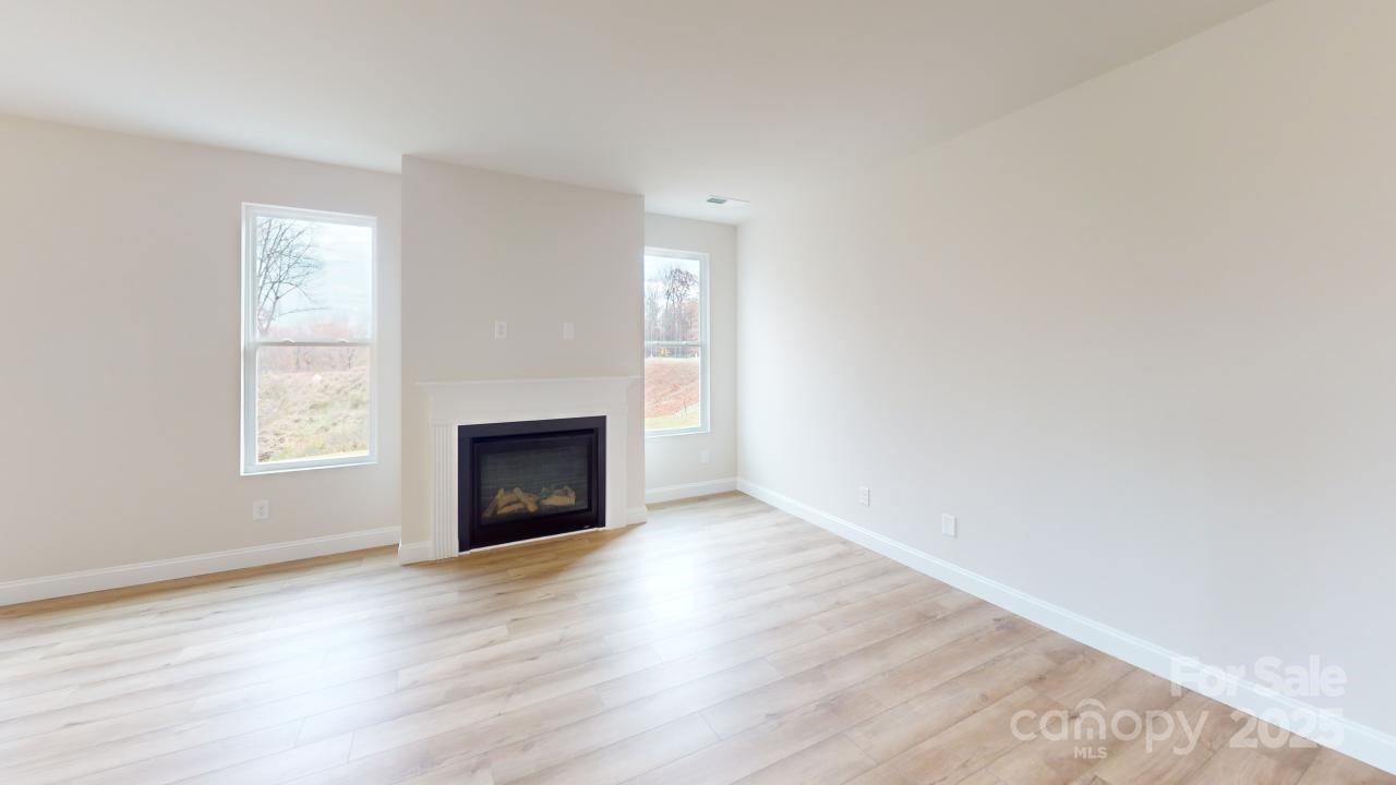 515 Tates Trail, Unit 39 Cramerton, NC 28056 - Photo 17 of 33 an empty room with wooden floor fireplace and windows
