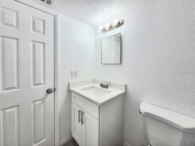 a bathroom with a sink toilet and mirror