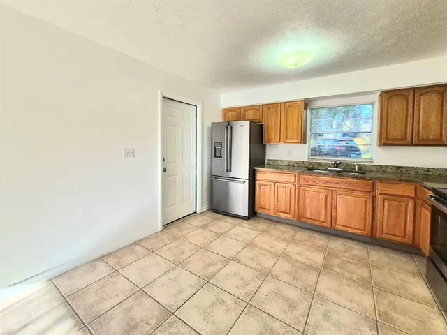 a kitchen with stainless steel appliances granite countertop a refrigerator and a stove top oven