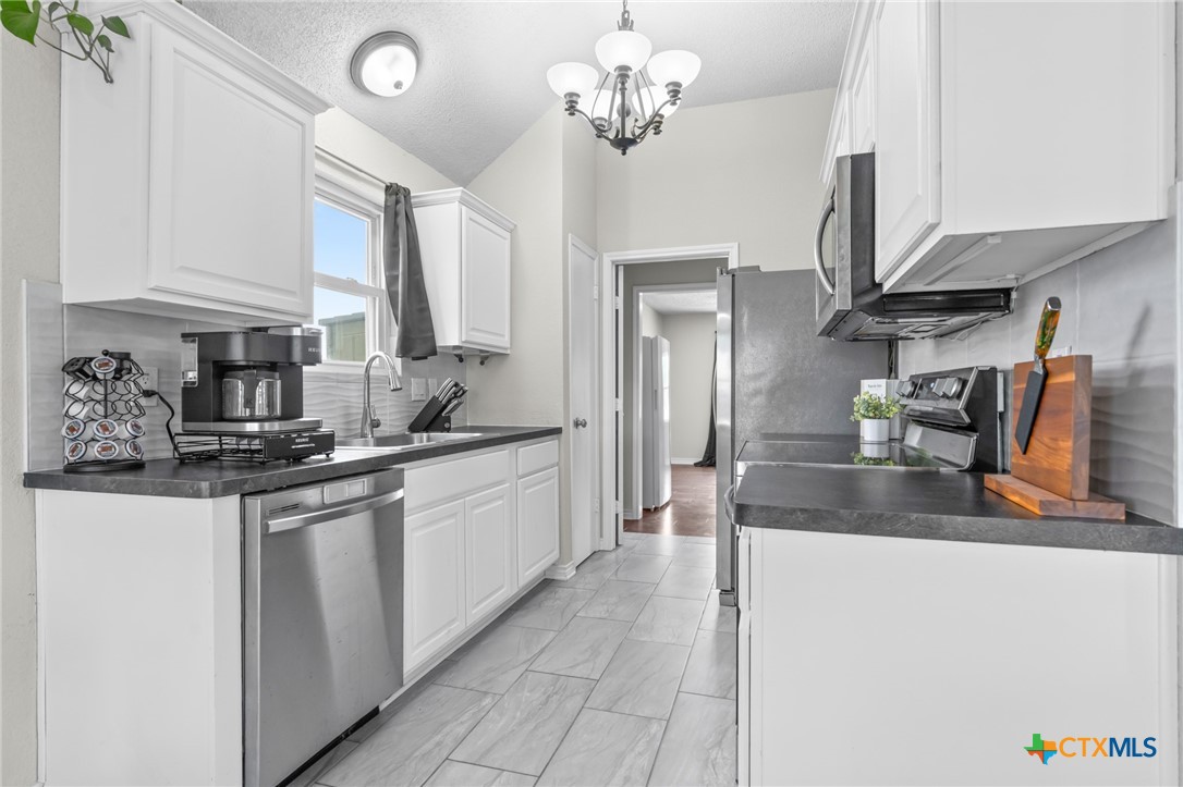 2804 Bluejay Drive Killeen, TX 76549 - Photo 11 of 36 a kitchen with stainless steel appliances granite countertop a sink a stove and cabinets