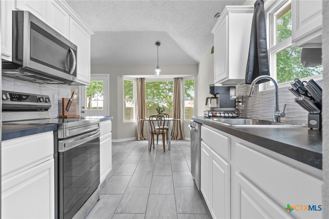 2804 Bluejay Drive Killeen, TX 76549 - Photo 13 of 36 a kitchen with stainless steel appliances granite countertop a stove a sink and a microwave