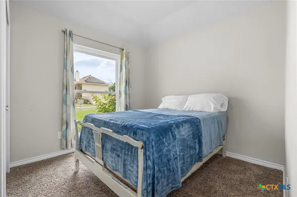 a bed sitting in a bedroom next to a window