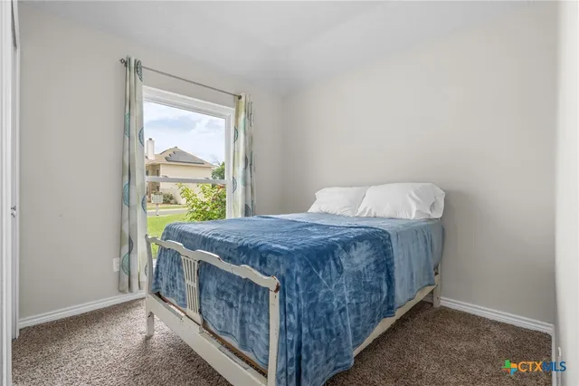 a bed sitting in a bedroom next to a window