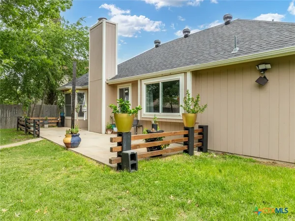 a view of a house with backyard sitting area and garden