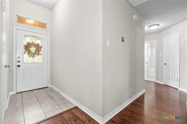 an empty room with wooden floor and painting on the wall