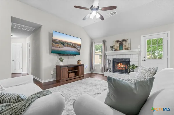 a living room with furniture a fireplace and a flat screen tv