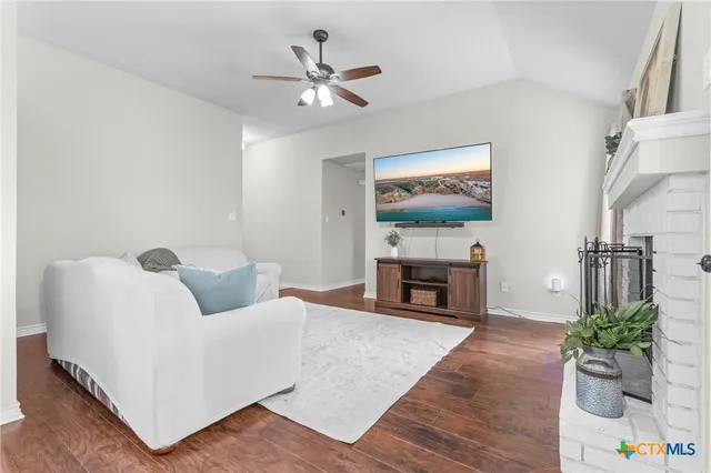 a living room with furniture a fireplace and a flat screen tv