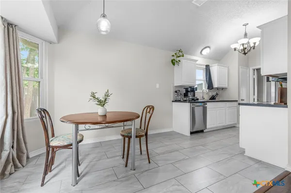 a view of a dining room with furniture and chandelier