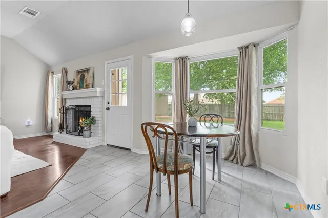 a dining room with furniture a fireplace and wooden floor