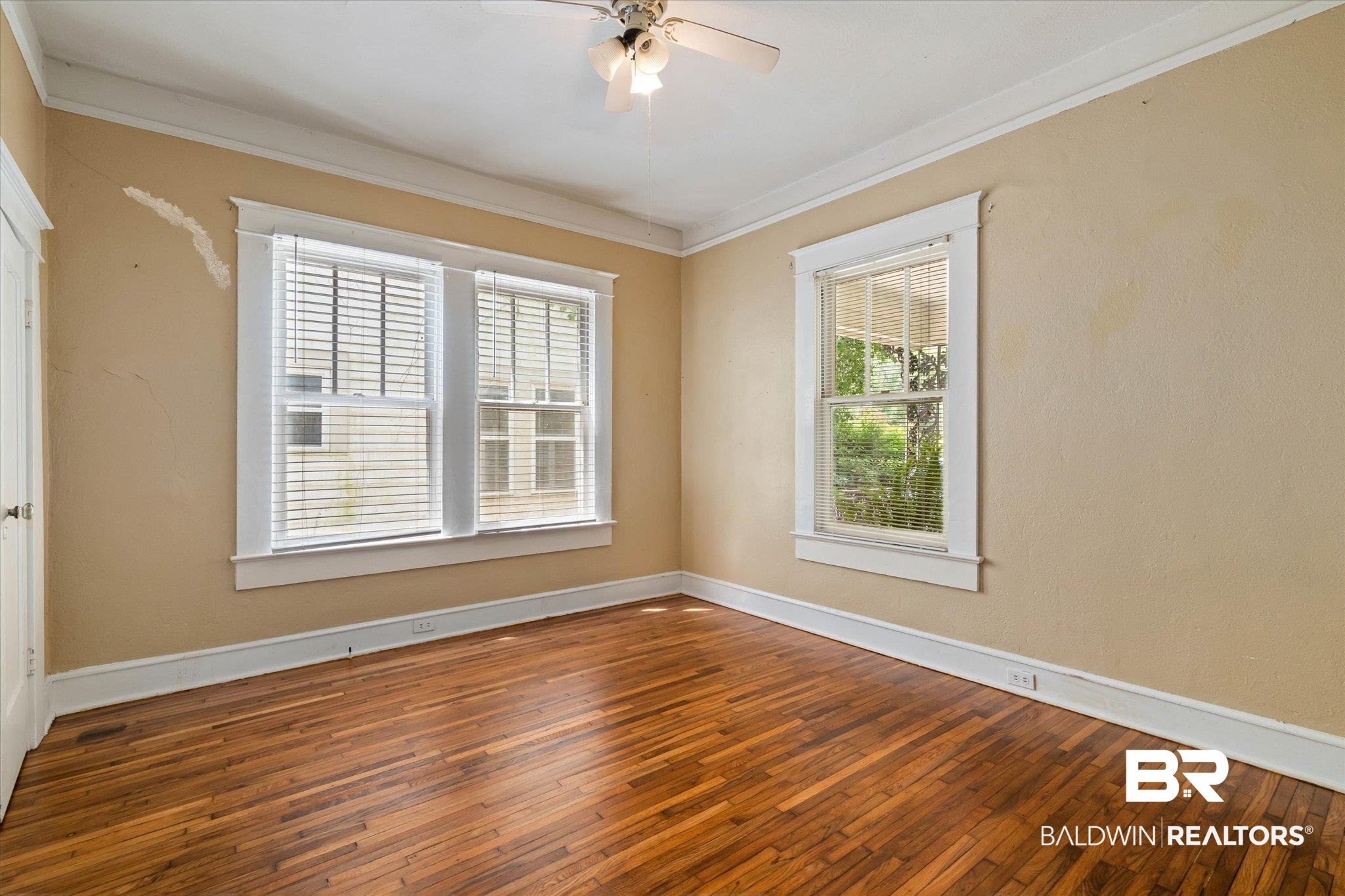 121 Westwood Street Mobile, AL 36606 - Photo 14 of 20 Empty room with baseboards, a wealth of natural light, ornamental molding, and wood-type flooring