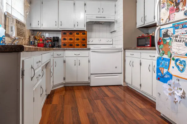 a kitchen with cabinets and wooden floor