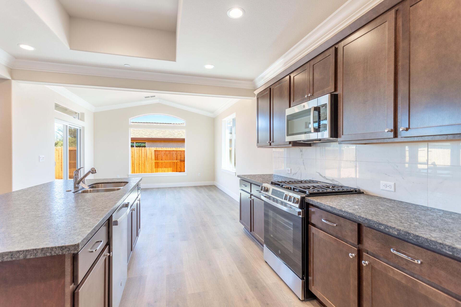 3063 Karuk Avenue Redding, CA 96002 - Photo 6 of 30 a kitchen with stainless steel appliances granite countertop a sink stove and cabinets