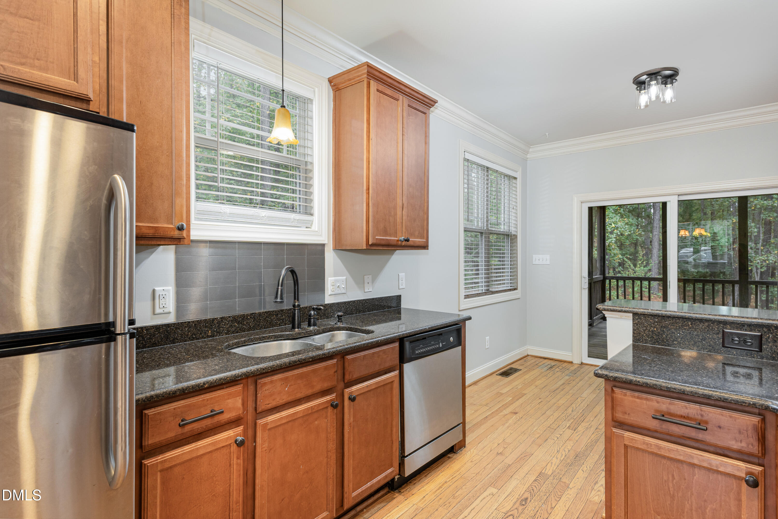 204 Blair Hills Road Wendell, NC 27591 - Photo 9 of 24 a kitchen with granite countertop a refrigerator a sink and wooden cabinets