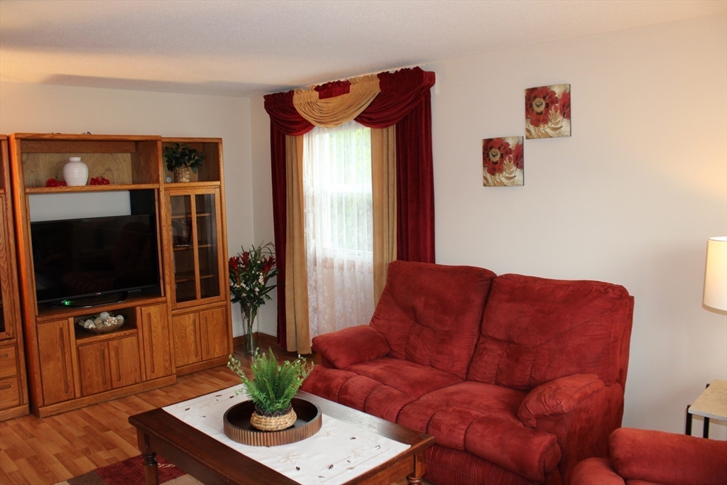 28 State Street Chicopee, MA 01013 - Photo 12 of 25 a living room with furniture flat screen tv and a window