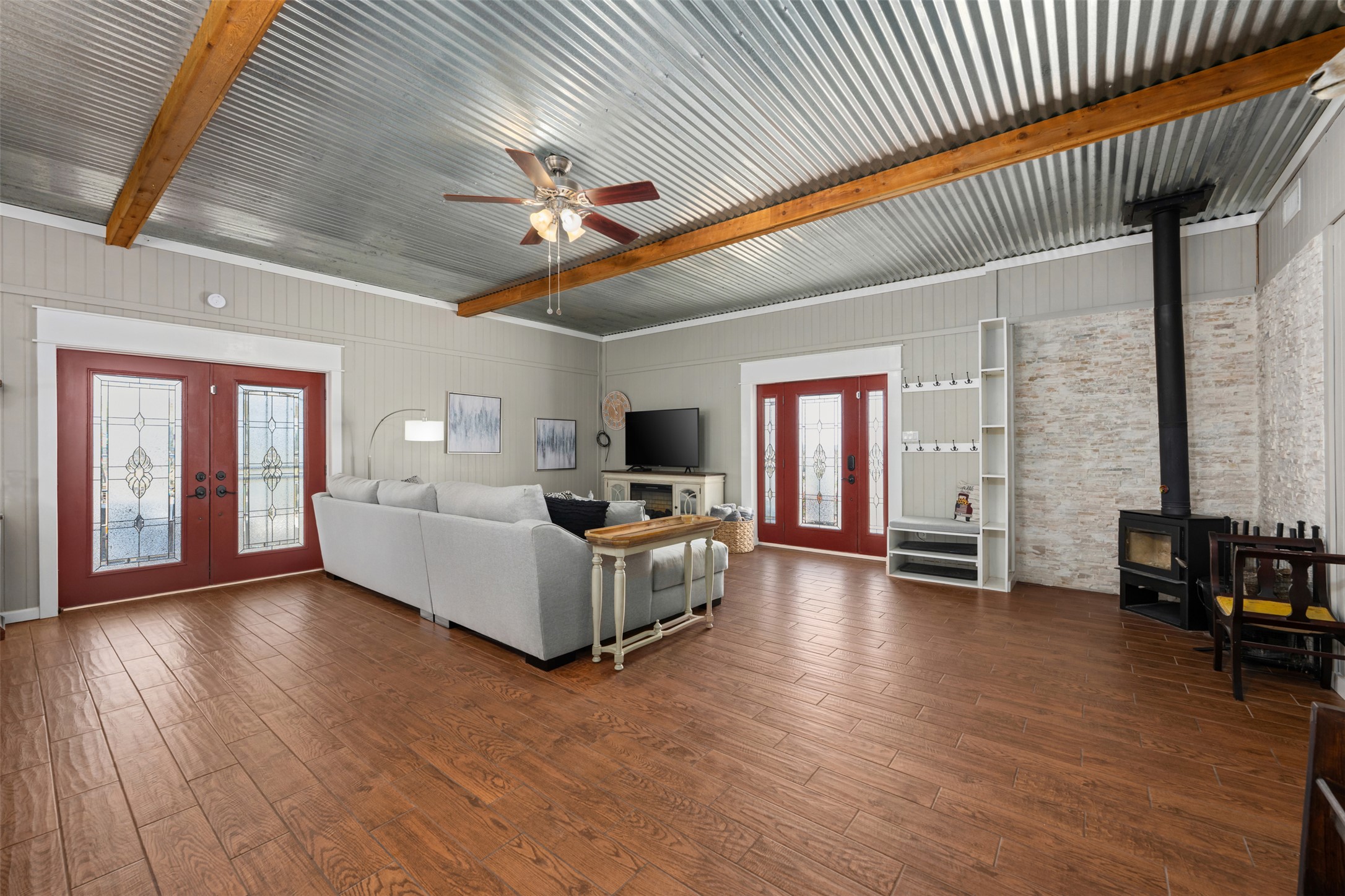 6501 County Road 239 Jarrell, TX 76537 - Photo 5 of 40 Living area featuring french doors, ceiling fan, a wood stove, dark wood-style floors, and beam ceiling