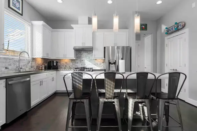 a kitchen with a table chairs refrigerator and cabinets