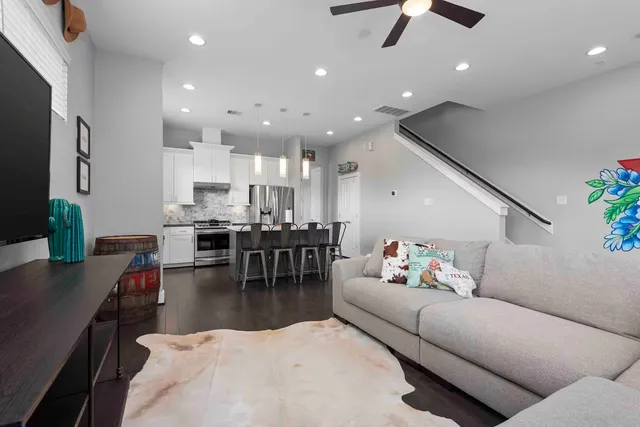 a living room with furniture kitchen view and a large window