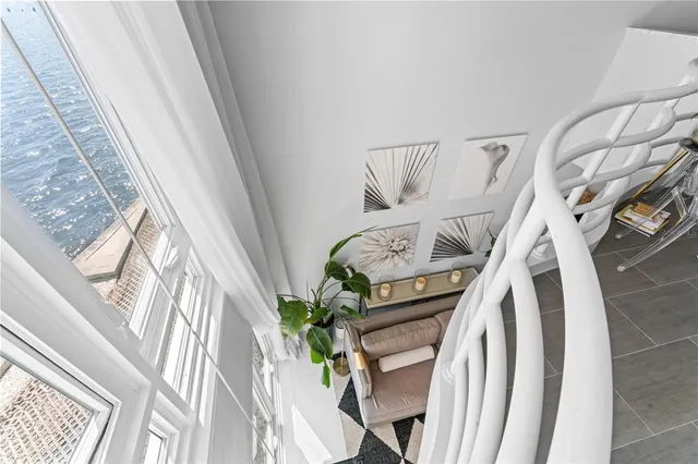 a roof deck with table and chairs under an umbrella with potted plants