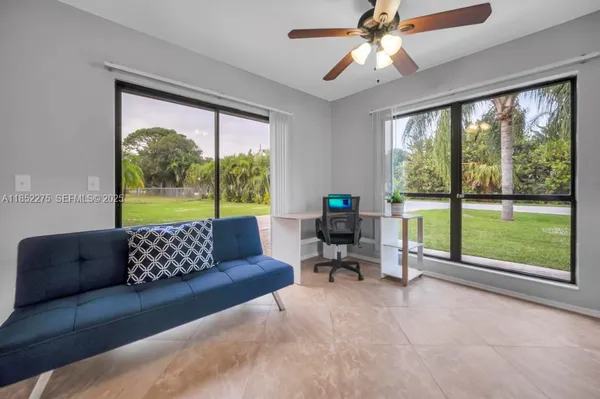 a living room with furniture and a floor to ceiling window