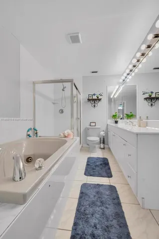 a spacious bathroom with a tub a sink and mirror