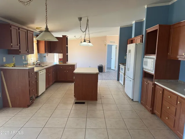 a kitchen with stainless steel appliances a sink a stove a refrigerator and cabinets