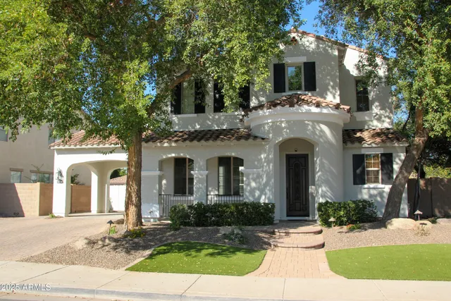 a front view of a house with yard and trees