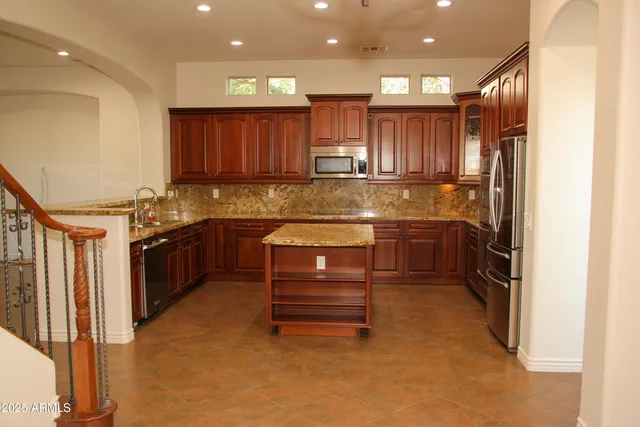 a kitchen with kitchen island a stove a sink and refrigerator