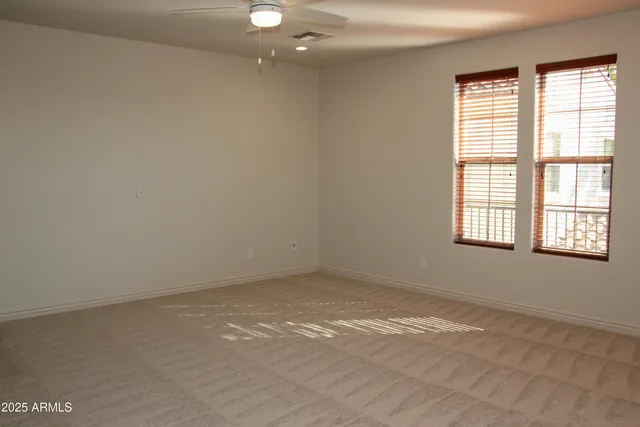 a view of an empty room with stairs and a window