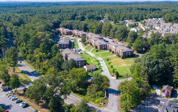 an aerial view of residential houses with outdoor space and trees