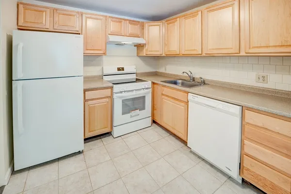 a kitchen with stainless steel appliances granite countertop a refrigerator sink and white cabinets