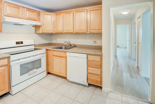 a kitchen with white cabinets and white appliances