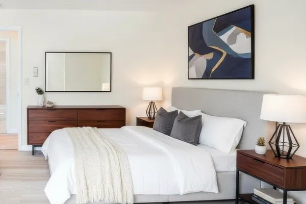 a bedroom with a bed and painting on the wall