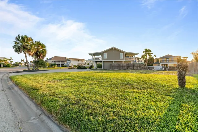 a view of a lake with a yard and wooden fence