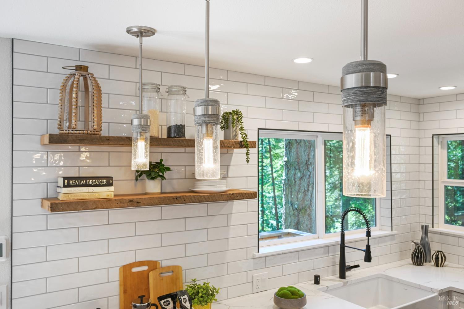 a kitchen with stainless steel appliances granite countertop a sink a counter space cabinets and living room view