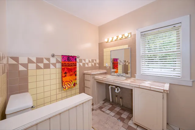 a bathroom with a granite countertop sink a mirror a bathtub and shower