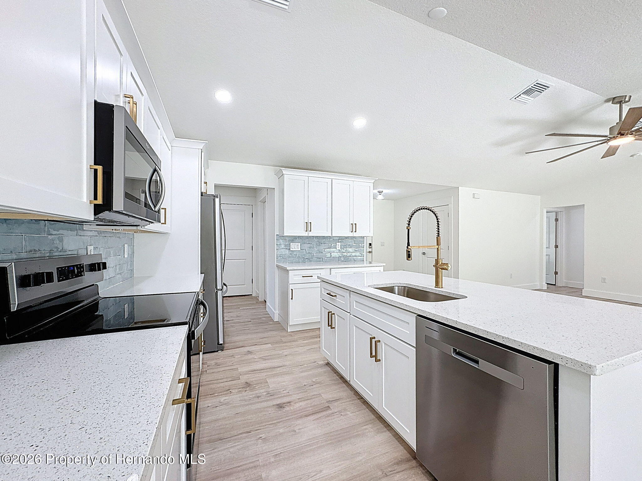 8988 Waterbird Way Weeki Wachee, FL 34613 - Photo 16 of 42 a kitchen with a sink stove and cabinets